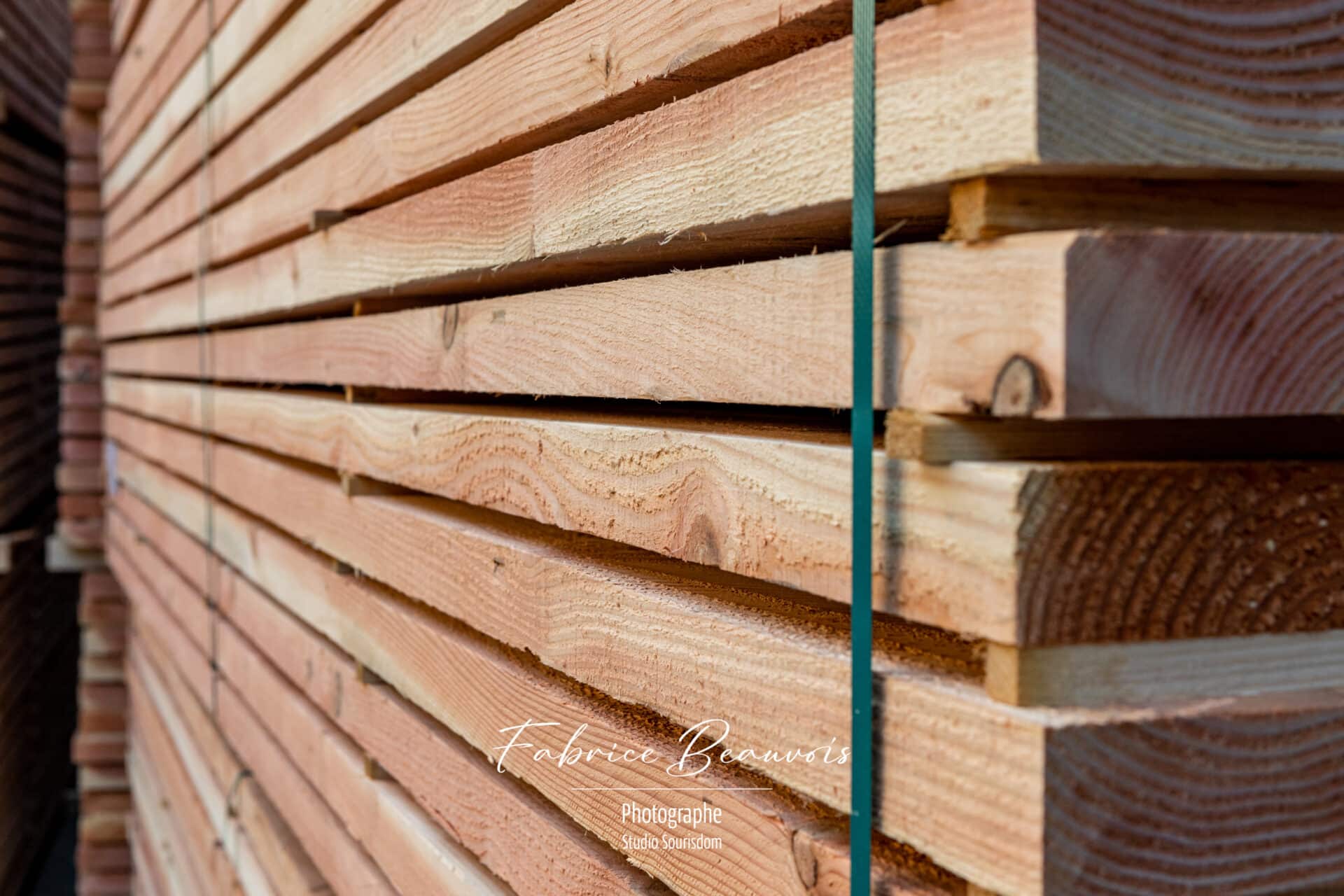 Planches de bois rangés méthodiquement sur le site de la scierie Béal avant toute expédition