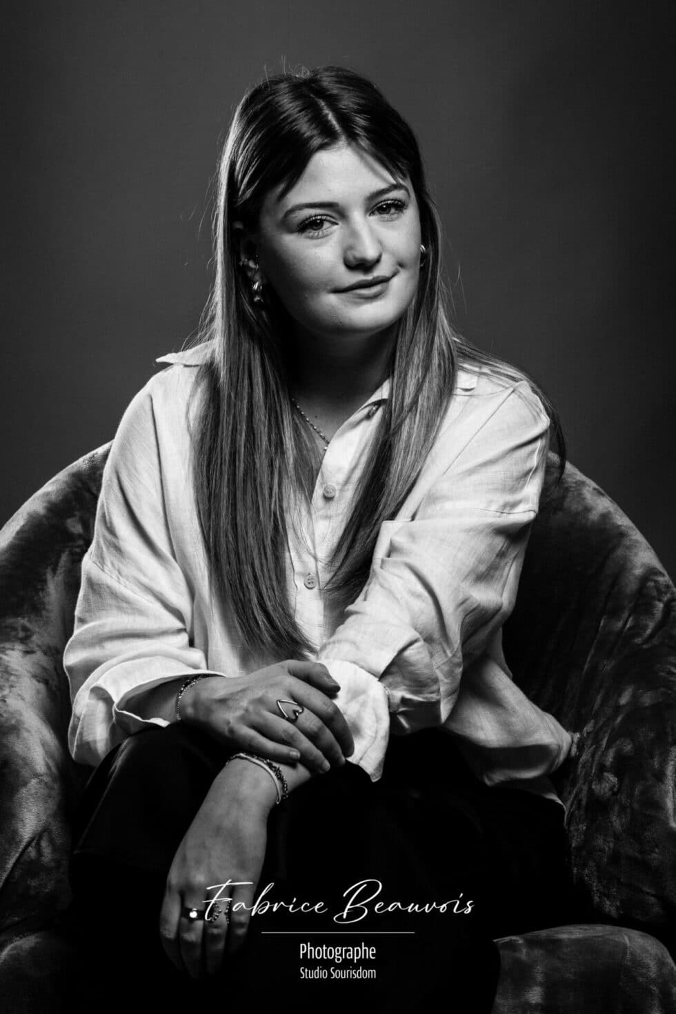 Portrait assis dans un fauteuil avec un flash positionné en hauteur face au modèle