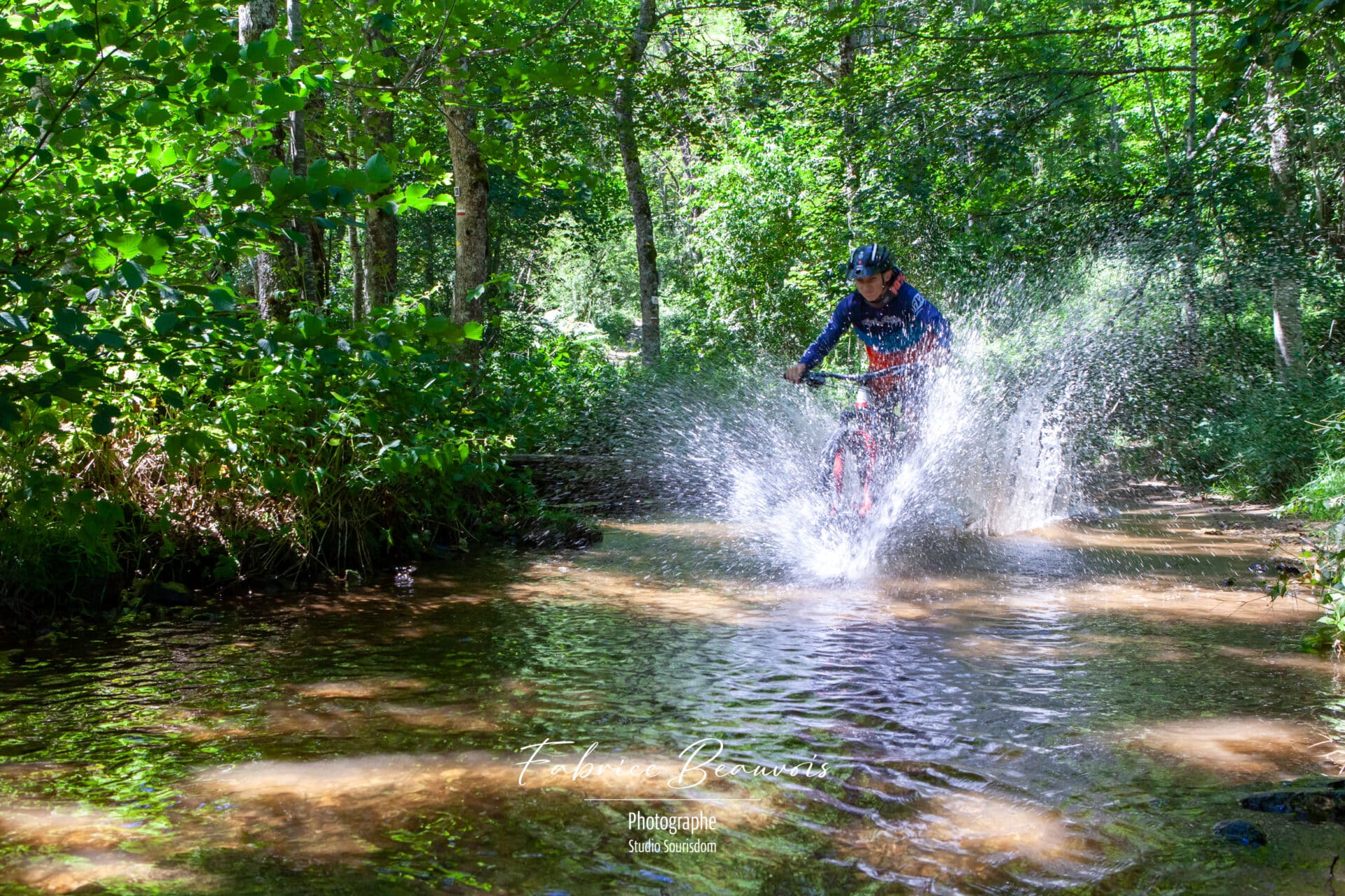 Passage à travers l'eau d'un VTT au détour d'un chemin