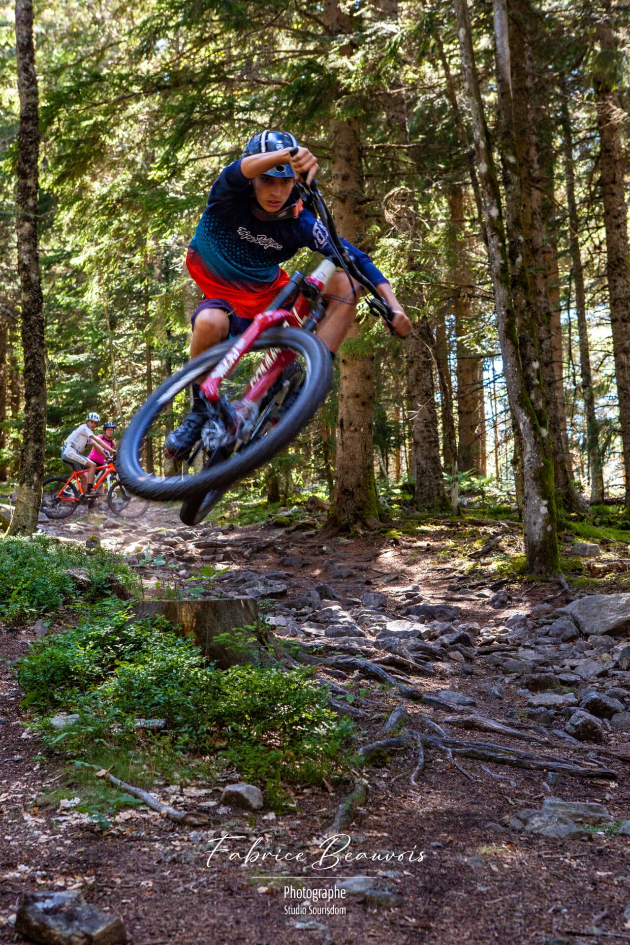 VTT effectuant une figure acrobatique après avoir sauté sur une souche d'arbre